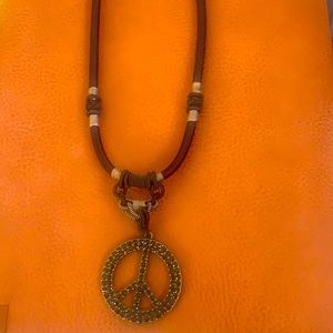 Black knit necklace with peace sign hanging about 2 inches from end of necklace